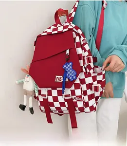 Detail of red and white checkerboard backpack with fashion label and plush doll charms