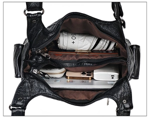 Top-down view of black soft leather crossbody bag showing spacious interior with multiple pockets