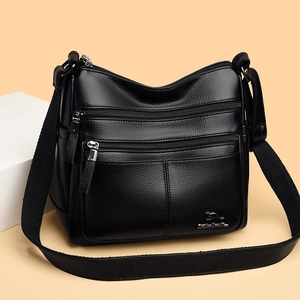 Minimalist black faux leather crossbody bag with multiple zippers and wide strap