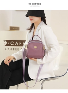 Dettaglio della borsa viola in tessuto Oxford con trama in nylon e logo dorato
