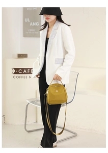 Dettaglio della borsa in nylon oxford giallo senape con targhetta logo in metallo dorato