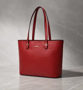 Dettaglio della borsa tote trapuntata rossa con logo dorato e manici eleganti da portare