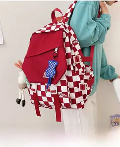 Side view of red checkerboard canvas backpack with cute plush charms and large pockets