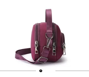 Vista laterale della borsa in nylon viola impermeabile con tre scomparti con cerniera