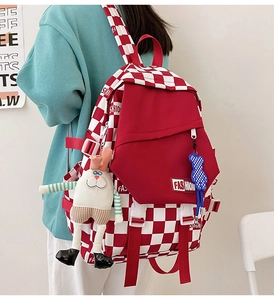 Side view of red checkerboard backpack with rabbit charm and adjustable straps