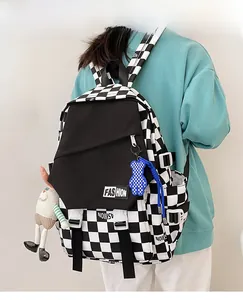Detail of checkered backpack with side pockets and decorative bear doll pendant