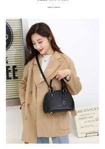 Fashionable black crocodile texture shell bag with gold buckle on a camel coat outfit