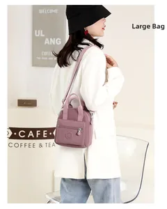 Side view of a large dusty pink nylon crossbody bag worn by a model in a cozy cafe setting
