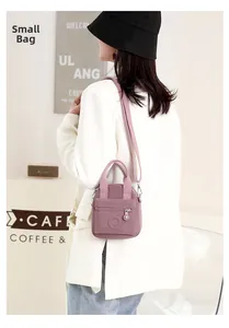 Detail shot of a purple nylon crossbody bag with circular logo and zipper compartment
