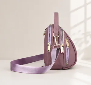 Vista laterale della borsa a conchiglia in nylon viola con tre scomparti e dettagli dorati