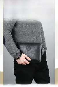 Détail de la pochette pour hommes en cuir PU noir texturé avec logo et fermeture éclair