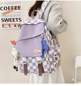 Detail of purple checkerboard backpack featuring cute charms and adjustable buckle closure