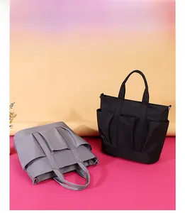 Detail of lightweight nylon tote bags in grey and black with multiple pockets