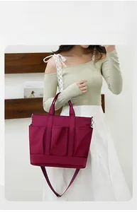 Macro detail of wine red nylon crossbody bag featuring three functional front utility pockets
