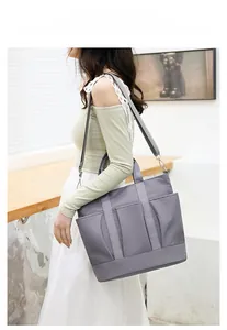 Detail shot of a dark grey waterproof nylon crossbody bag with functional outer pockets