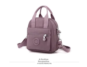 Side view of purple nylon crossbody bag featuring front zipper and adjustable strap