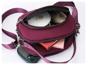 Vista interna della borsa a tracolla in nylon bordeaux che mostra tasche e capienza
