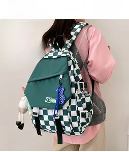 Side view of checkered backpack with bear charm and plush doll detail on model