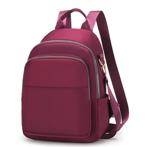 Sac à dos femme en nylon bordeaux avec multiples compartiments zippés et détails dorés