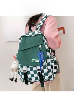 Detail of green checkerboard backpack featuring bear and bunny charms and side buckles