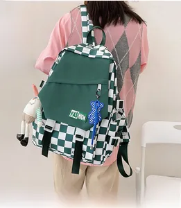 Detail of green checkerboard backpack with fashion patch, buckle and cute plush charms