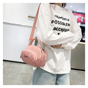 Vista street style di una borsa a tracolla in nylon trapuntato rosa con ampia tracolla regolabile