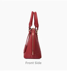 Side view of red crocodile embossed leather shell bag with gold zipper and dual handles