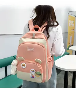 Detailed view of pink and beige patchwork nylon backpack with bear ears and cute badges