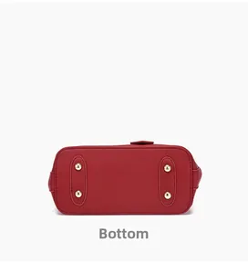 Detailed bottom view of red leather handbag featuring four golden metal protective feet
