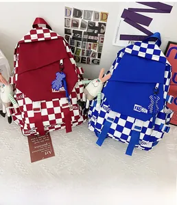 Close-up of checkerboard backpacks in red and blue with plush bunny and bear charms
