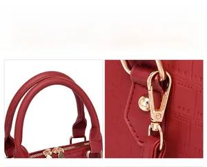 Detail of red crocodile texture handbag with premium gold zippers and metal hardware