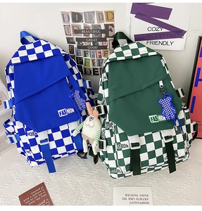 Close-up of checkerboard backpacks in blue and green with cute plush pendants
