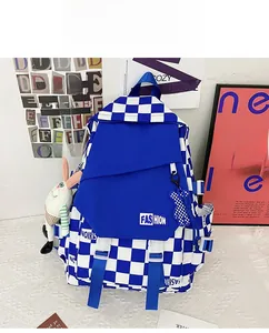 Detail of blue checkerboard backpack with fashion patch and cute plush animal charms