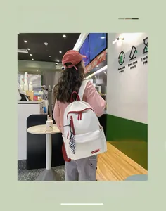 Détails du sac à dos en nylon blanc avec bordures rouges et charme en damier