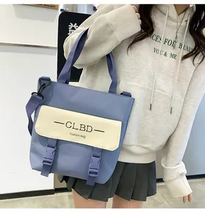 Detail of blue and beige patchwork crossbody bag with secure plastic buckle closures