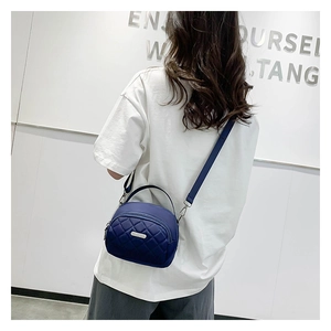 Vista dettagliata di una borsa a tracolla in nylon trapuntato blu scuro su un modello