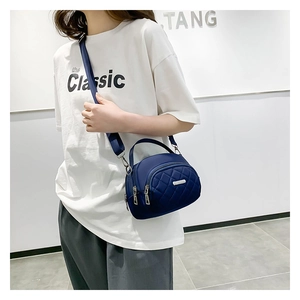 Dettaglio della borsa a tracolla trapuntata in nylon blu navy con cerniere argentate