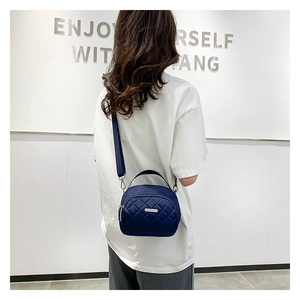 Dettaglio della borsa a tracolla trapuntata in nylon blu navy con cerniere argentate
