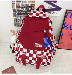 Detail of red and white checkered backpack with fashion patch and cute plush charms