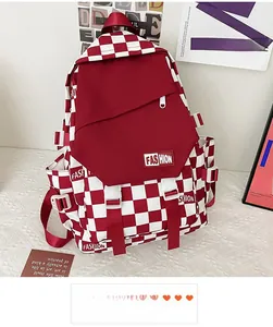 Detail of red and white checkerboard backpack featuring a prominent FASHION letter patch