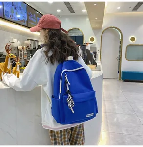 Sac à dos en nylon bleu avec fermetures blanches et porte-clé à damier décoratif