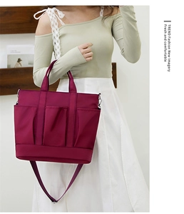 Detailed view of burgundy nylon crossbody bag featuring quilted design and shoulder strap