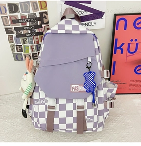 Detail of purple checkerboard backpack with fashion tags and cute plush doll accessories