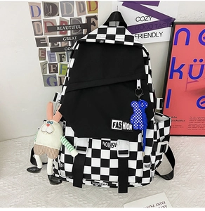 Detail of checkered backpack featuring fashion label, bear and rabbit plush charms