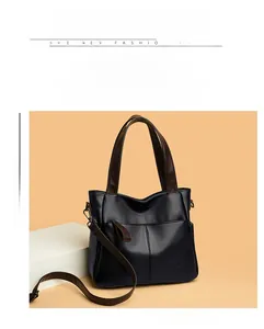 Detail of black lychee texture leather handbag with brown handles and kangaroo logo