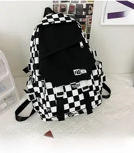 Detail view of checkerboard backpack featuring large pocket with buckle straps and side adjustment
