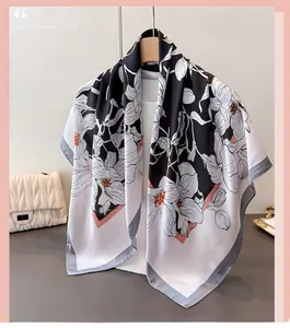 Détail d'un foulard en satin à imprimé floral suspendu à un cintre en bois