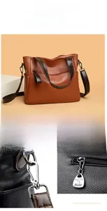 Detail of silver polished hardware and zipper pockets on brown leather tote bag