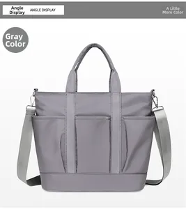 Front view of grey nylon crossbody bag with three large pockets and adjustable strap