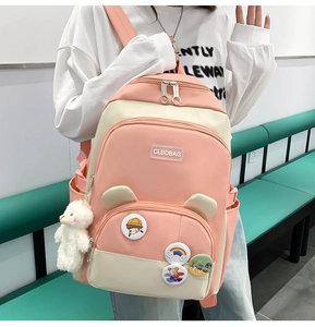 Pink and beige school backpack featuring cute badges and a plush lamb pendant detail